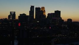 5.7K aerial stock footage flying by the city skyline lit for the night at twilight, Downtown Minneapolis, Minnesota Aerial Stock Footage | DX0001_002580
