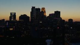 5.7K aerial stock footage ascend by the city skyline lit for the night at twilight, Downtown Minneapolis, Minnesota Aerial Stock Footage | DX0001_002581