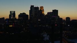 5.7K aerial stock footage descend by the city skyline lit for the night at twilight, Downtown Minneapolis, Minnesota Aerial Stock Footage | DX0001_002582