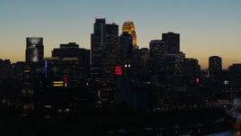 5.7K aerial stock footage pass by smoke stacks and the city skyline lit for the night at twilight, Downtown Minneapolis, Minnesota Aerial Stock Footage | DX0001_002584
