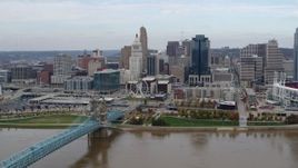 5.7K aerial stock footage of a reverse view of the city skyline and bridge by Ohio River, Downtown Cincinnati, Ohio Aerial Stock Footage | DX0001_002598