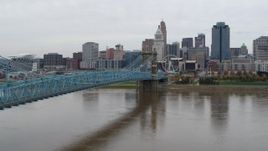 5.7K aerial stock footage descend near the Roebling Bridge spanning Ohio River near the city skyline, Downtown Cincinnati, Ohio Aerial Stock Footage | DX0001_002640