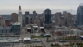 5.7K aerial stock footage of flying by tall skyscrapers and skyline near Ferris wheel in Downtown Cincinnati, Ohio Aerial Stock Footage | DX0001_002670