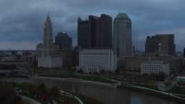 5.7K aerial stock footage flyby the city skyline and the Scioto River at sunset during ascent, Downtown Columbus, Ohio Aerial Stock Footage | DX0001_002747