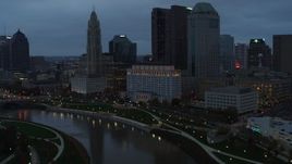 5.7K aerial stock footage of flying by Scioto River and city skyline at sunset, Downtown Columbus, Ohio Aerial Stock Footage | DX0001_002756