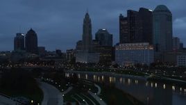 5.7K aerial stock footage of flying by the river and the city skyline at twilight in Downtown Columbus, Ohio Aerial Stock Footage | DX0001_002765