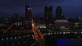5.7K aerial stock footage of flying by the city's skyline across a bridge and river at twilight, Downtown Columbus, Ohio Aerial Stock Footage | DX0001_002786