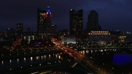 5.7K aerial stock footage of passing a bridge spanning the river and city skyline at twilight, Downtown Columbus, Ohio Aerial Stock Footage | DX0001_002791