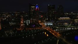 5.7K aerial stock footage of flying by the city skyline, and bridge spanning the river at night, Downtown Columbus, Ohio Aerial Stock Footage | DX0001_002798