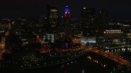5.7K aerial stock footage of flying by LeVeque Tower and bridge spanning the river at night, Downtown Columbus, Ohio Aerial Stock Footage | DX0001_002801