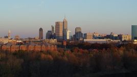 5.7K aerial stock footage of the city's skyline at sunset, seen from trees, Downtown Indianapolis, Indiana Aerial Stock Footage | DX0001_002930