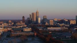 5.7K aerial stock footage of passing the city's downtown skyline at sunset before ascent, Downtown Indianapolis, Indiana Aerial Stock Footage | DX0001_002934