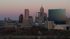 5.7K aerial stock footage pan and ascend by hotel and the city's skyline at sunset, Downtown Indianapolis, Indiana Aerial Stock Footage | DX0001_002938