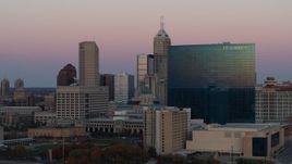 5.7K aerial stock footage of flying by hotel to reveal the city's skyline at sunset, Downtown Indianapolis, Indiana Aerial Stock Footage | DX0001_002940