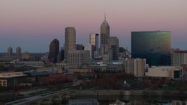 5.7K aerial stock footage of flying away from hotel and city's skyline at sunset, Downtown Indianapolis, Indiana Aerial Stock Footage | DX0001_002942