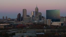 5.7K aerial stock footage of descending near hotel and city's skyline at sunset, Downtown Indianapolis, Indiana Aerial Stock Footage | DX0001_002943
