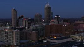 5.7K aerial stock footage fly away from city skyline at twilight, reveal factory with smoke stacks, Downtown Indianapolis, Indiana Aerial Stock Footage | DX0001_002965