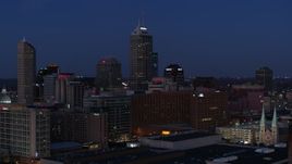 5.7K aerial stock footage pass giant skyscrapers of the city skyline at twilight, seen from smoke stacks, Downtown Indianapolis, Indiana Aerial Stock Footage | DX0001_002971