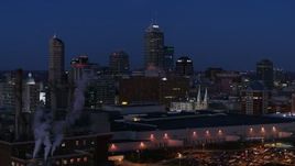 5.7K aerial stock footage flyby smoke stacks and the city skyline during descent at twilight, Downtown Indianapolis, Indiana Aerial Stock Footage | DX0001_002976