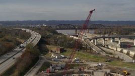 5.7K aerial stock footage construction crane near railroad bridge and locks and a dam on the Ohio River in Louisville, Kentucky Aerial Stock Footage | DX0001_003017