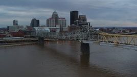 5.7K aerial stock footage descend by bridge with view of the skyline at sunset, Downtown Louisville, Kentucky Aerial Stock Footage | DX0001_003067