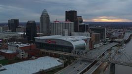 5.7K aerial stock footage fly away from arena and skyline, reveal bridge and Ohio River at sunset, Downtown Louisville, Kentucky Aerial Stock Footage | DX0001_003069