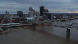 5.7K aerial stock footage of the arena and skyline, seen while flying by bridge and Ohio River at sunset, Downtown Louisville, Kentucky Aerial Stock Footage | DX0001_003070