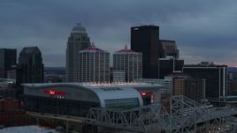 5.7K aerial stock footage ascend by arena at sunset and focus on the skyline, Downtown Louisville, Kentucky Aerial Stock Footage | DX0001_003091