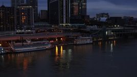 5.7K aerial stock footage orbit small riverboat beside a historic ship at twilight in Downtown Louisville, Kentucky Aerial Stock Footage | DX0001_003095