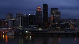 5.7K aerial stock footage of reverse view of the skyline lit up at twilight, and the Ohio River, Downtown Louisville, Kentucky Aerial Stock Footage | DX0001_003101