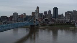 5.7K aerial stock footage of the city skyline and Roebling Bridge seen from the Ohio River, Downtown Cincinnati, Ohio Aerial Stock Footage | DX0001_003133