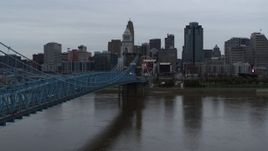 5.7K aerial stock footage descend by bridge toward river, with view of the city skyline, Downtown Cincinnati, Ohio Aerial Stock Footage | DX0001_003136
