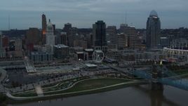 5.7K aerial stock footage of the city skyline seen from the Roebling Bridge over the river at sunset, Downtown Cincinnati, Ohio Aerial Stock Footage | DX0001_003153