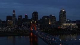 5.7K aerial stock footage ascend from Roebling Bridge lit up at twilight, approach city skyline, Downtown Cincinnati, Ohio Aerial Stock Footage | DX0001_003173