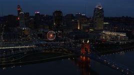 5.7K aerial stock footage flying by lights of city skyline and bridge at twilight, seen from river, Downtown Cincinnati, Ohio Aerial Stock Footage | DX0001_003178