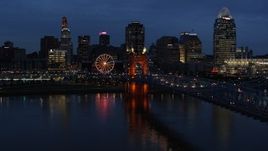 5.7K aerial stock footage of lights of city skyline and bridge at twilight while descending by river, Downtown Cincinnati, Ohio Aerial Stock Footage | DX0001_003180
