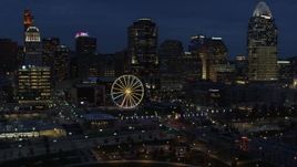 5.7K aerial stock footage flying by Ferris wheel and skyscrapers at twilight, Downtown Cincinnati, Ohio Aerial Stock Footage | DX0001_003185