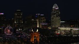 5.7K aerial stock footage of passing by tall skyscrapers and Ferris wheel at night in Downtown Cincinnati, Ohio Aerial Stock Footage | DX0001_003193