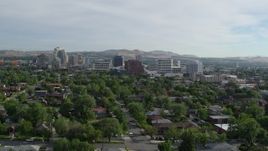 5.7K aerial stock footage of a view of casino resorts and office buildings seen from neighborhood with trees in Reno, Nevada Aerial Stock Footage | DX0001_006_017