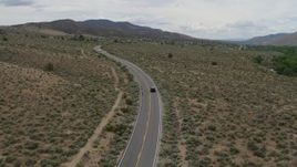 5.7K aerial stock footage of a black SUV cruising on a desert road in Carson City, Nevada Aerial Stock Footage | DX0001_007_027