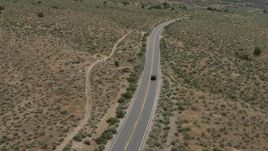 5.7K aerial stock footage of a black SUV driving on a lonely desert road in Carson City, Nevada Aerial Stock Footage | DX0001_007_030