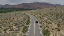 5.7K aerial stock footage of a black SUV driving by on a desert road in Carson City, Nevada Aerial Stock Footage | DX0001_007_032