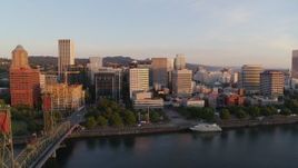4K aerial stock footage flying away from Downtown and toward the Hawthorne Bridge at sunrise, Downtown Portland, Oregon Aerial Stock Footage | DX0001_010_017