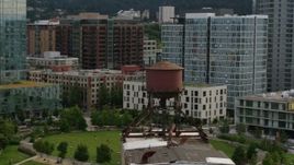 5.7K aerial stock footage orbiting an old water tower atop a factory building, sunset, Downtown Portland, Oregon Aerial Stock Footage | DX0001_013_017