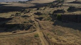 5.7K aerial stock footage of ascending beside a dirt road to reveal Lewis and Clark Highway in Goldendale, Washington Aerial Stock Footage | DX0001_019_030