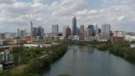 5.7K aerial stock footage descend toward Lady Bird Lake and focus on skyline of Downtown Austin, Texas Aerial Stock Footage | DX0002_102_024
