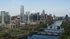 5.7K aerial stock footage ascend for view of towering skyscrapers and bridges over Lady Bird Lake, Downtown Austin, Texas Aerial Stock Footage | DX0002_104_014