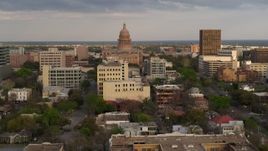 5.7K aerial stock footage of the Texas State Capitol behind office buildings at sunset in Downtown Austin, Texas Aerial Stock Footage | DX0002_104_036
