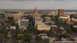 5.7K aerial stock footage flyby the Texas State Capitol behind office buildings at sunset in Downtown Austin, Texas Aerial Stock Footage | DX0002_104_037