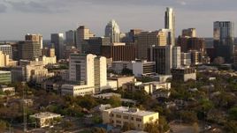 5.7K aerial stock footage of flying by a courthouse and office buildings near skyscrapers at sunset in Downtown Austin, Texas Aerial Stock Footage | DX0002_104_039